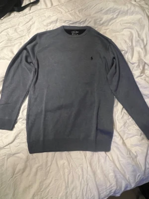 Grå tröja från Polo Ralph Lauren XL - Snygg grå tröja från Polo Ralph Lauren i storlek L men känns mer som L. OBS! Aldrig använd endast testad. 
