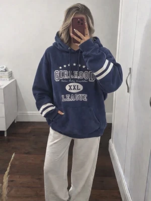 Marinblå oversized hoodie med tryck från H&M Divided, strlk S - En marinblå hoodie med tryck i oversize passform i storlek S från H&M DIVIDED men är köpt secondhand och är använd några gånger men fortfarande i bra/fint skick! Finns inga synliga tecken på användning vad jag kan se. FÖRST TILL KVARN!