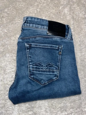 Replay jeans  - Marinblåa jeans från Repaly med snygga kontrastmönster. De har en smal passform med skönt och stretchigt matrial. Midja 36cm, längd 100cm. JAG SKICKAR EJ FLER BILDER NÄR JAG BÄR JEANSEN! för bättre inblick i passformen rekommenderar jag att googla på modellnamnet. För storleksguide kolla måtten noggrant då jeansen alltid kan vara uppsydda heller krympta och jag ej tar emot returer :) s6,5