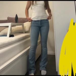 Blå bootcut jeans med låg midja - Snygga ljusblå bootcut jeans med låg midja och klassisk femficksdesign. Jeansen har en tight passform över låren och släpper ut nedtill för en trendig siluett. Perfekta till en enkel topp eller hoodie för en avslappnad look.