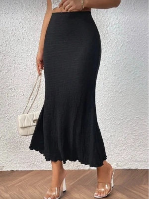 Svart långkjol i stretchigt tyg - Snygg svart långkjol med lätt utsvängd nederdel och figurnära passform. Kjolen är enkel och stilren, tillverkad i ett stretchigt material som sitter bekvämt på kroppen. Perfekt att styla med crop tops eller stickade tröjor.