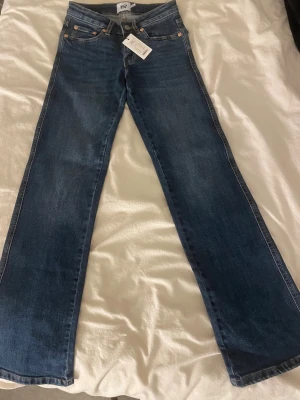 Blå bootcut jeans från 157 - Säljer ett par blå bootcut jeans från 157 med klassisk femficksdesign och snygga kontrastsömmar. Jeansen har full längd och är tillverkade i bomullsmix för en bekväm passform. Perfekta för dig som gillar en retroinspirerad look.
