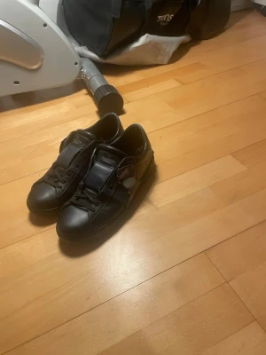 Svarta Valentino Garavani sneakers - Snygga svarta sneakers från Valentino Garavani med mörkblå detaljer och klassisk låg siluett. Skorna har läderöverdel, svarta skosnören och diskret logga på plösen. Perfekta för dig som gillar exklusiv streetstyle. Såklart äkta ‼️‼️