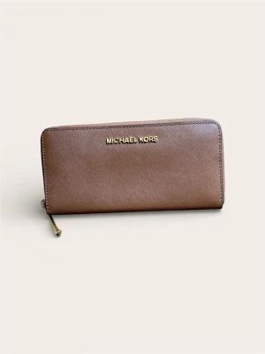 Michael Kors Plånbok – Brun Saffiano (Klassisk modell) - Säljer en Michael Kors plånbok i den klassiska bruna färgen med detaljer i guld. Modellen är en "Zip-around" (dragkedja runt om) vilket gör den säker och rymlig.  Gjord i tåligt Saffiano-läder som står emot repor och smuts väldigt bra. Inuti finns gott om plats för kort, sedlar samt ett mittenfack med dragkedja för mynt.  Skick: Fint begagnat skick!  Mått:  Bredd: 21 cm  Höjd: 11 cm Nypris: Ca 1500 kr. 