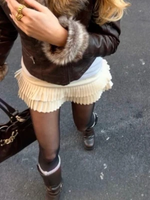 Plisserad vit kortkjol - Supersnygg vit kortkjol med plisserad nederkant. Kjolen har en klassisk midja och är perfekt för att styla med boots eller sneakers. Tillverkad i ett mjukt material som känns bekvämt hela dagen. Enkel att matcha med olika toppar för en trendig look.