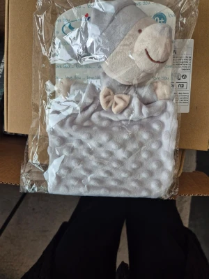 Grå snuttefilt med nallehuvud - Mysig snuttefilt från Interbaby i ljusgrått med mjukt nallehuvud och liten rosett framtill. Filten har en bubblig struktur och är tillverkad i plyschliknande material. Perfekt för små barn att gosa med.