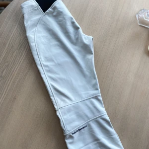 Vita skidbyxor från Peak Performance - Så snygga vita skidbyxor från Peak i tight passform, som håller sig på plats när man åker och väldigt sköna. Storlek S, något liten i storleken.   ”Softshellbyxor med varm fleece på insidan. Smal, kroppsnära passform med fast stretch. Perfekta för piståkning”  Använda men jättefint skick. Inga defekter.   Nypris ca 4000.