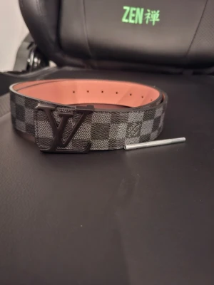 Svart bälte - Svart bälte med silvrigt spänne, hål görare  ingår, aldrig använd