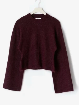 Vinröd croppad stickad tröja - Mysig vinröd stickad tröja med croppad passform och vida ärmar. Tröjan har rund halsringning och är tillverkad i ett fluffigt, mjukt material som ger en trendig look.