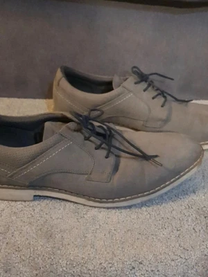 Grå mockaloafers med snörning - Snygga loafers i grå mocka med klassisk snörning och kontrastsömmar. Skorna har en låg profil och vit sula som ger en stilren look. Perfekta för dig som vill ha en clean och enkel stil till vardags. Passar till både jeans och chinos.