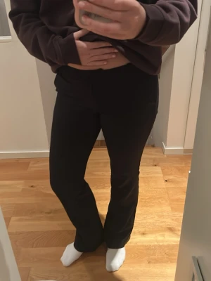 Svarta kostymbyxor bootcut - Säljer ett par svarta kostymbyxor med bootcut-modell och pressveck. Byxorna har hällor för skärp och diskreta bakfickor. Perfekta för en clean och stilren look. Materialet känns mjukt och följsamt.
