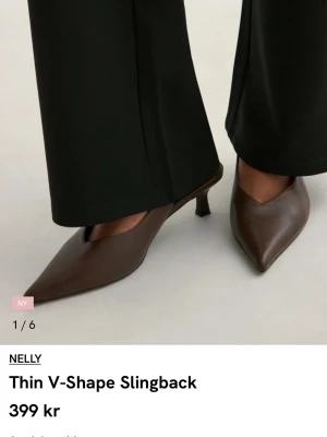 Bruna slingback pumps från Nelly - Snygga bruna pumps med V-formad tå och smal rem runt hälen från Nelly. Skorna har en låg klack och är tillverkade i ett slätt material som ger en stilren look. Perfekta för dig som gillar minimalistisk design och vill ha ett par trendiga slingbacks. Små i strl (dessa är 38 men passar 37 eller 37 1/2) Skolåda finns kvar 