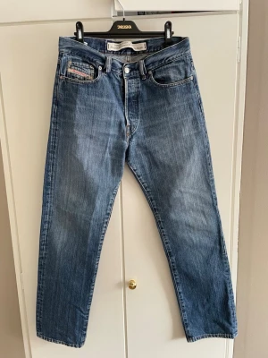 Vintage jeans från Diesel - Säljer ett par vintage jeans från Diesel med rak passform. Jeansen har en snygg wash och är i utmärkt skick. Modellen heter fellow och är som ett par vanliga raka jeans, är gjorda i 100% bomull. Storleken är 33/30 men skulle säga att de passar som 32/31. Tveka inte på att höra av dig om du har några frågor.