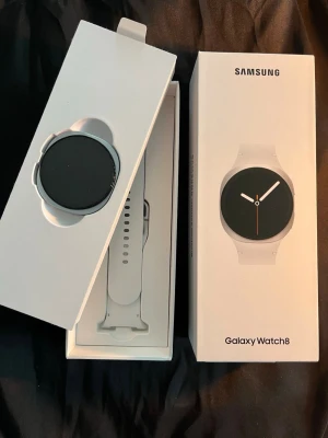 Helt ny, oanvänd Samsung Galaxy Watch8 vit smartklocka - Snygg Samsung Galaxy Watch8 i vit färg med rund urtavla och silikonarmband. Modern och stilren design, perfekt för dig som gillar teknik och vill ha koll på hälsa och notiser direkt på handleden. Kommer i originalförpackning (inköpsdokument finns såklart) . Strl 44mm, färg: Silver, armband : Vit 
