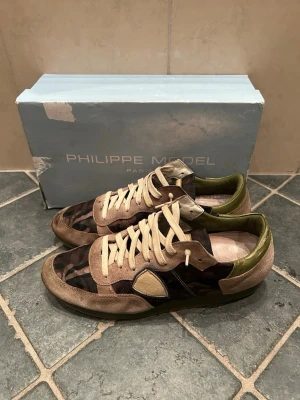 Philippe Model camo sneakers - Snygga sneakers från Philippe Model med camouflage-mönster i grönt, brunt och beige. Rätt så använda (se bild) kan sänka pris vid snabb affär.