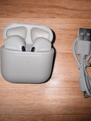 PodsX 4 - Säljer nu dessa snygga och smidiga trådlösa hörlurar i vitt, inspirerade av designen hos AirPods Pro 4. De sitter bekvämt i öronen och ger ett klart och balanserat ljud. Perfekt för musik, samtal och träning.  Kompakt och stilren design  Touchkontroller  Laddningsetui medföljer  Lightning laddare medföljer  Kompatibla med både iPhone och Android  Helt nya och oanvända! Skick: 10/10. Perfekt som budgetvänligt alternativ till AirPods Pro 4.
