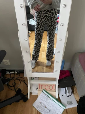 Leopardmönstrade leggings från Gina Tricot - Säljer ett par snygga leopardmönstrade leggings från Gina Tricot. De är vita med svart och grått mönster, har hög midja och är stretchiga för en skön passform. Perfekta för dig som vill sticka ut lite extra!