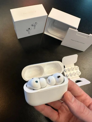 Apple AirPods Pro trådlösa hörlurar - Säljer ett par vita Apple AirPods Pro med laddningsetui och extra silikonpluggar. Hörlurarna har en stilren och kompakt design i blank plast och levereras i originalförpackning. Perfekta för dig som vill ha brusreducering och grymt ljud i ett smidigt format.