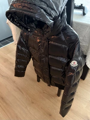 Moncler svart höstjacka  - Säljer en stilren Moncler jacka i svart glansigt material. Perfekt höstjacka när det börjar bli kallare ute men man fortfarande vill ha en snygg och clean look ✨