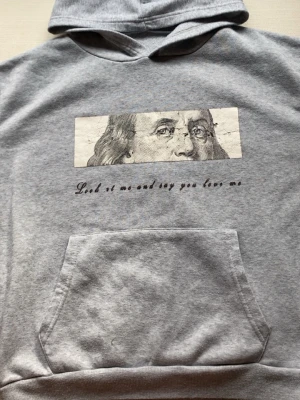 Grå hoodie med tryck och ficka - Grå hoodie med tryck och ficka från shein. trycket är lite sönder. Ganska liten i storlek.