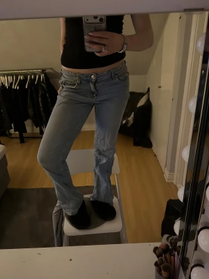 Ljusblå bootcut jeans - Säljer ett par ljusblå bootcut jeans med låg midja och klassisk femficksmodell. Jeansen har en avslappnad passform och är perfekta för en casual look. Materialet är denim i bomull och de har en snygg vintage vibe.