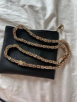 Guldigt kedjehalsband från kejsar 6mm (18k stämpel) - Säljer ett snyggt guld halsband från kejsar med en robust och detaljerad kedjedesign. Halsbandet har en unik låsdetalj och känns riktigt exklusivt. Perfekt för dig som vill sticka ut med accessoarer i metall och gillar statement-smycken. 18k stämpel