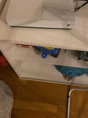 Xbox One S vit spelkonsol - Säljer en Xbox One S spelkonsol i snygg vit färg med stilren, rektangulär design. Konsolen har ventilerad ovansida och klassisk Xbox-logga på framsidan. Perfekt för gaming och streaming, passar alla som gillar spel och underhållning. Finns i södertälje/ gnesta