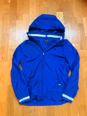 Blå vindjacka Polo Ralph Lauren - Snygg blå vindjacka från Polo Ralph Lauren som passar bra inför våren, sommaren och hösten.      🌸☀️🍁 Perfekt för lite blåsiga dagar. Den passar för en som är mellan 160-168.
