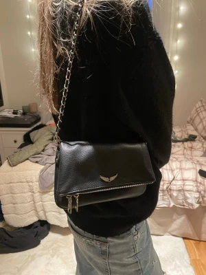 Svart axelväska med kedjerem - Fin zadig & voltaire (fejk) väska som är köpt utomlands. Den har ett långt och ett kort band som kan bytas! Även lite slitage men inget som märks när man har på sig den🩷
