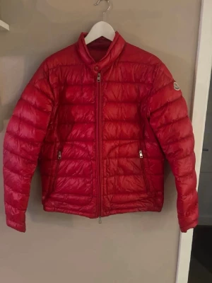 Röd moncler jacka  - En riktigt fet moncler jacka för våren storlek 3 vilket motsvara m/l! Skriv vid intresse eller funderingar.