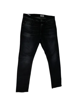 Tiger of Sweden Pistolero Jeans  - Säljer ett par stilrena jeans från Tiger of Sweden i modellen Pistolero. Färgen heter "Nighter" och är en snyggt tvättad svart/mörkgrå ton med diskreta slitningar (whiskers) framtill. Modellen Pistolero har en modern slim-fit passform med avsmalnande ben (tapered) och normal midja. Jeansen har stretch vilket gör dem mycket bekväma. • Modell: Pistolero • Färg: PRG:NIGHTER (Washed Black) • Storlek: W29 / L30 • Skick: Mycket gott skick, sparsamt använda. Inget synligt slitage mellan benen eller vid