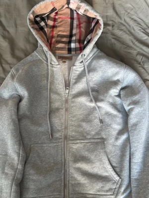 Grå Burberry hoodie - Snygg grå zip hoodie från Burberry. Hoodien är i storlek M ( Passar även S ). Skriv om du har några fler frågor