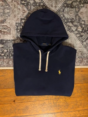 Mörkblå Polo Ralph Lauren Hoodie - Hej!👋  Säljer en mörkblå fleece hoodie från Polo Ralph Lauren. Hoodien är i mycket gott skick och har inga fläckar eller hål. Storlek: S i herrstorlek, 170/92A. Skickar gärna mått på begäran.✅ Skickar snabbt🚛📦 Hör av er vid frågor!💯😀