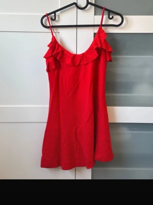 Röd volangklänning med smala axelband från Zara! Slutsåld överallt! Så himla fin!  - Så himla fin! Superbra skick. Blev slutsåld överallt men kan inte använda längre pga viktuppgång 