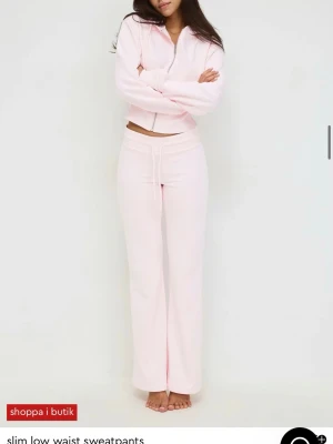 Ljusrosa slim low waist mjukisbyxor - Säljer ett par ljusrosa mjukisbyxor med slim fit och låg midja. Byxorna har raka ben och dragsko i midjan för skön passform. Perfekta för en avslappnad och trendig look. Tillverkade i mjukt material som känns bekvämt hela dagen. Köpta för 600kr slutsålda på hemsidan säljer hela settet för 400kr  byxorna är i m tröjan i S skulle säga att dem är små i storlekarna 