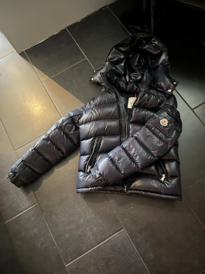Hej, säljer en moncler Maya. - Säljer en moncler Maya jacka som nu börjar bli för liten. Den är i mycket gott skick. Den är väll använd och bara använd en vinter. Priset kan diskuteras. Nfc funkar på in sidan av jackan vid QR koden