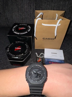 Svart Casio G-Shock klocka - Säljer en svart Casio G-Shock klocka med digital och analog display. Klockan har robust design, resinarmband och är vattentät upp till 200 meter. Kommer med originalförpackning, manual och garanti. Perfekt för dig som gillar sportig och tålig stil.