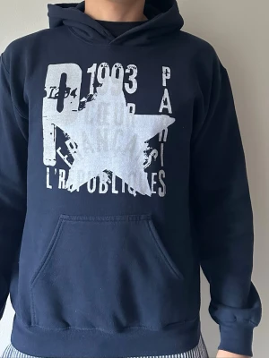 Mörkblå hoodie med tryck och ficka - En mörkblå hoodie från Zandro studio. 