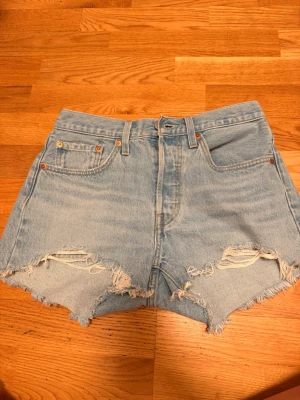 Levi's ljusblå jeansshorts med slitningar - Ljusblå jeansshorts från Levi's, använts fåtal gånger och är som nya. Är öppen för att diskutera priset. 💕