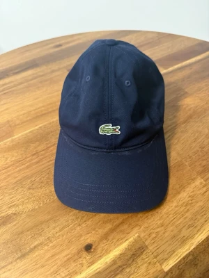 Lacoste Keps Marinblå Onesize - Säljer en Lacoste keps marinblå. Storlek: Onesize Köpt på Zalando.