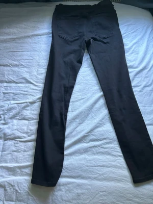 Svarta diesel jeans - Säljer ett par svarta skinny/straight jeans med hög midja och två klassiska bakfickor. Jeansen har en smal passform och är tillverkade i ett stretchigt material som sitter tajt längs benen. Perfekta för en clean och stilren look.