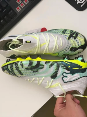 Puma Future fotbollsskor vit/gul STL. 41 - Säljer mitt helt nya par Puma future Storlek 41. Köpte dom för 4-5 dagar sedan. Använda bara 1 gång och då märkte jag att de va för stora. Hade returnerat dom om möjligt men slängde sko kartongen… har bild bevis på min beställning från unisport och de är bokstavligen helt nya! AG- för konstgräs