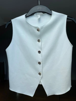 Topp - Elegant topp med rund halsringning och fina knappar framtill. Toppen har ett mjukt material och inte använd så mycket🤍