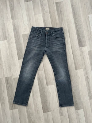 Grå slim straight jeans Jack & Jones - Snygga grå slim straight jeans från Jack & Jones med klassisk femficksmodell och slitna detaljer. Jeansen har normal midja, dragkedjegylf och är tillverkade i mjuk denim med lite stretch för extra komfort. Fråga mig om storlek osv
