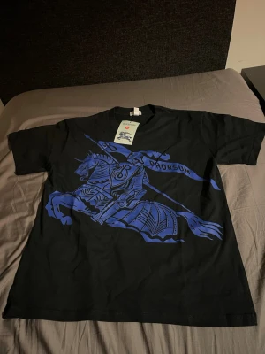 Svart Burberry t-shirt med blått tryck - Helt ny tröja aldrig använd, pris kan diskuteras vid snabb affär!!