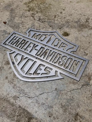 Harley-Davidson Emblem HD  3mm plåt 60x50 - Harley-Davidson väggskylt i metall med utskuret emblem. Snygg att hänga upp i garage, man cave eller hemma hos hojälskaren.  Måla den, spraya, lackera den i vilken färg du vill.