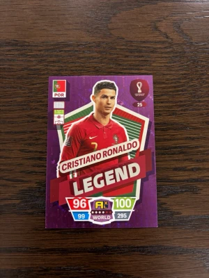 Cristiano Ronaldo Legend samlarkort - Unikt samlarkort från FIFA World Cup Qatar 2022 med Cristiano Ronaldo i Portugals landslagströja. Kortet har lila och röda färger, texten 'LEGEND' och flera stats. Perfekt för dig som gillar fotboll och samlar på sportkort.