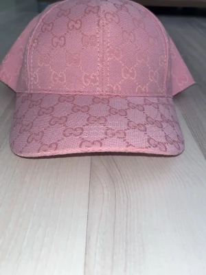 Rosa keps från zara med GG-mönster - Säljer en snygg rosa keps från Zara  med det klassiska GG-monogrammet över hela kepsen. Kepsen har böjd skärm och är tillverkad i ett tåligt tygmaterial. Perfekt accessoar för att lyfta din outfit och ge en exklusiv touch.