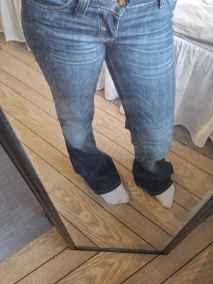 Blå bootcut jeans - Säljer ett par blå bootcut jeans med snygga och klassiska fickor. Jeansen har låg midja och är tillverkade i denim med lite stretch för skön passform. Perfekta till sneakers eller boots. 