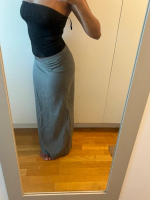 Khakigrön långkjol med slits från BikBok - Säljer en stilren khakigrön långkjol med slits bak. Kjolen har en rak passform och är enkel att matcha med olika toppar. Perfekt för dig som gillar minimalistisk stil och vill ha en kjol som funkar till många looks. Helt oanvänd, lapp sitter kvar:)